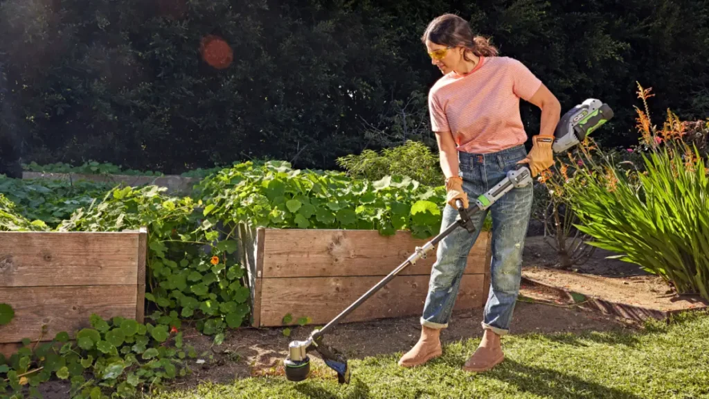 mulher aparando a grama da horta